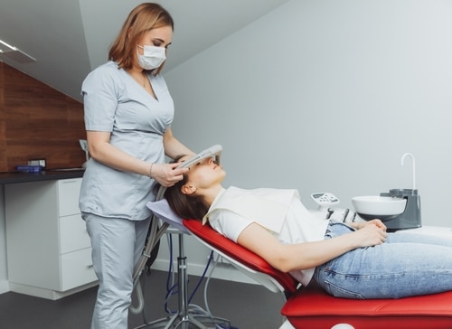 dentist assistant puts inhalation sedative mask on the patient.